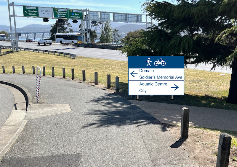 A photo soon after turning right at the eastern end of the Bridge of Remembrance. A wayfinding sign for pedestrians and cyclists has been added which shows Domain and Soldier's Memorial Avenue to the left and Aquatic Centre and City to the right.