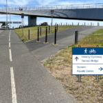 A photo taken on the approach to the eastern end of the Bridge of Remembrance from the Hobart CBD. A wayfinding sign for pedestrians and cyclists has been added which shows Intercity Cycleway and Tasman Bridge straight ahead and Domain and Aquatic Centre to the right.