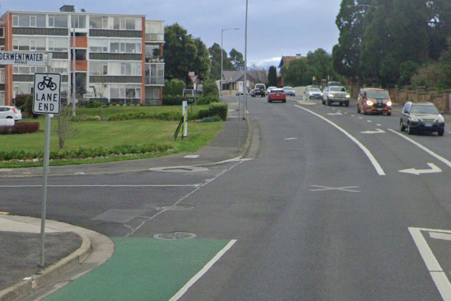 A green painted bike lane on Sandy Bay Road abruptly stops. There's a 'Bike Lane End' sign.