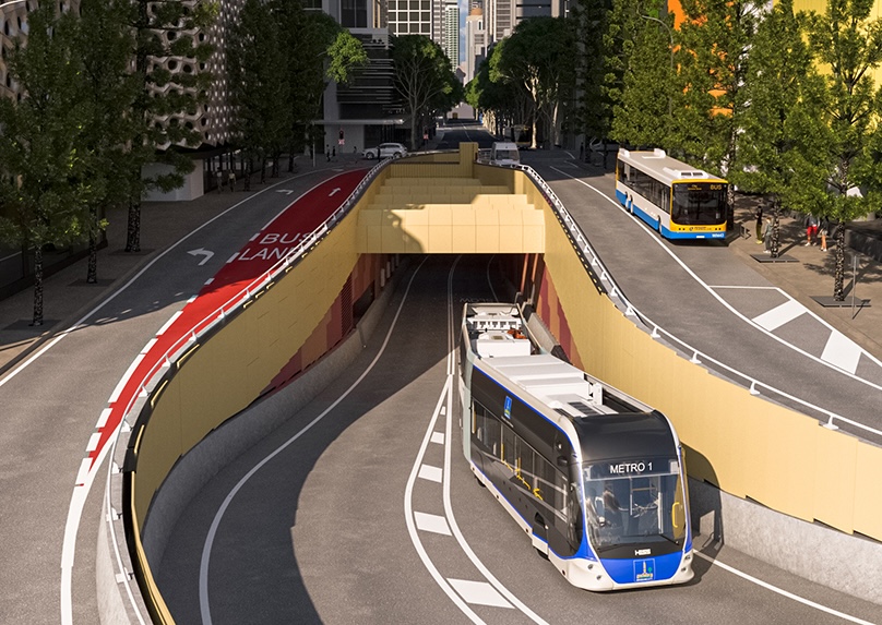 An articulated bus drives out of a tunnel.